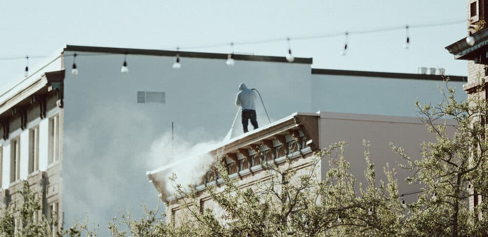 Worker cleaning a building roof