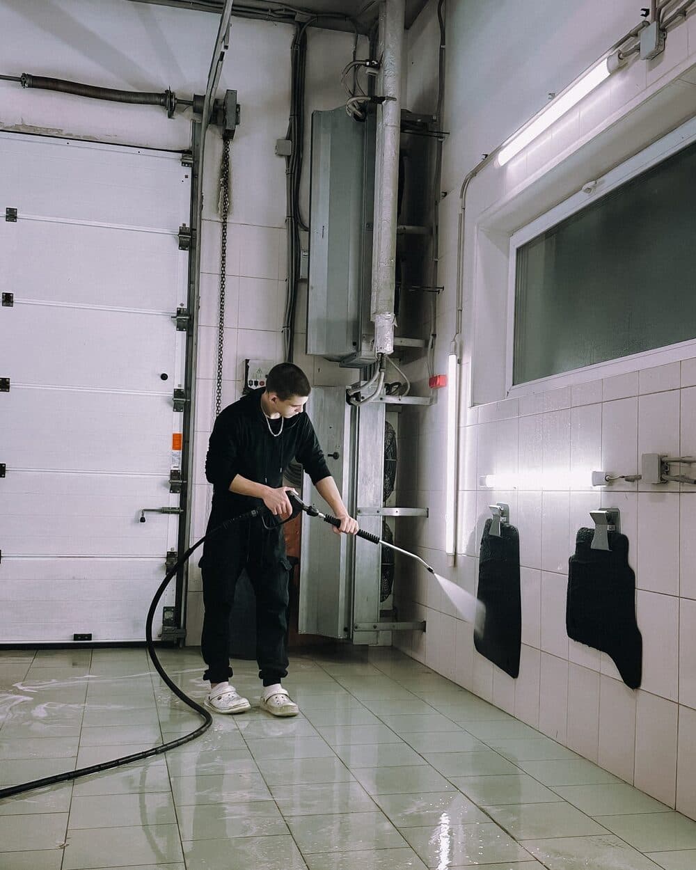 Floor mat being pressure washed